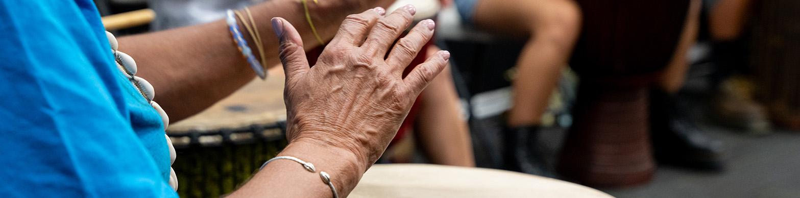Image of the hands of a black woman drumming