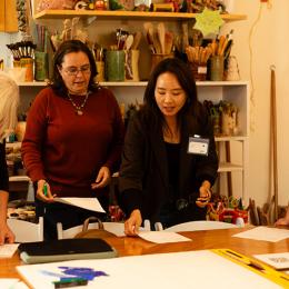 Four Women pour over a sheaf of papers